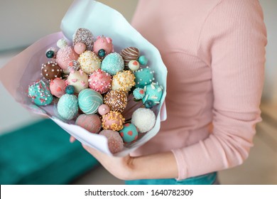 A bouquet of chocolate covered strawberries in young woman hands