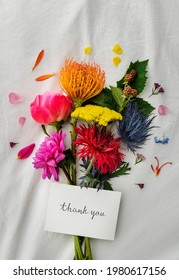 Bouquet of colorful flowers on a white bed sheet with a card mockup