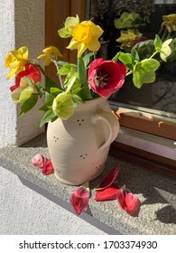 Bouquet Of Colorful Mixed Spring Flowers In Ceramic Vase Outside On A Granite Window Sill. Some Red Tulip Petals Have Already Fallen