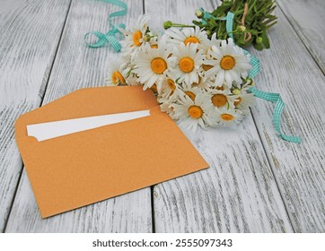 bouquet of daisies with envelope on a old wooden background - Powered by Shutterstock