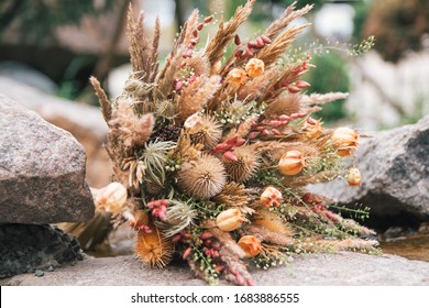 bouquet of dried flowers for the bride on the stones of the waterfall - Powered by Shutterstock