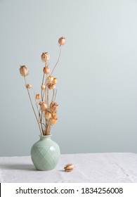 bouquet of dried flowers poppies in a green vase on a linen tablecloth on light green  background. Front view and copy space - Shutterstock ID 1834256008