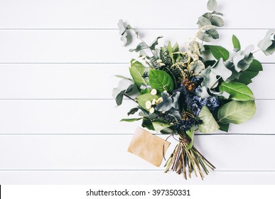 Bouquet of dried wild flowers on white table background  with natural wood vintage planks wooden texture top view horizontal, empty space for publicity information or advertising text - Powered by Shutterstock