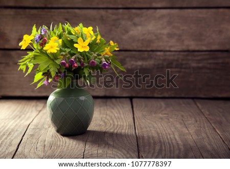 bouquet of field wild flowers in a vase on old boards.