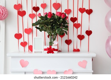 Bouquet Of Flowers, Blank Photo Frame, Gift Box And Engagement Ring On Mantelpiece Near Light Wall