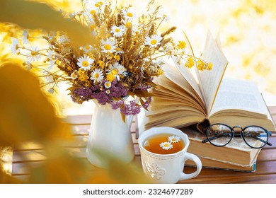 Bouquet of flowers, croissant, cup of tea or coffee, books on table in autumn garden. Rest in garden, reading books, breakfast, vacations in nature concept. Autumn time in garden on backyard - Powered by Shutterstock