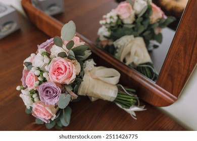 A bouquet of flowers is displayed in front of a mirror. The flowers are pink and white, and they are arranged in a vase. The mirror reflects the bouquet, creating a sense of depth and dimension - Powered by Shutterstock