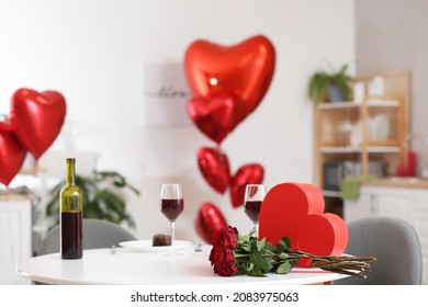 Bouquet Of Flowers, Gift Box And Red Wine On Table At Home. Valentine's Day Celebration