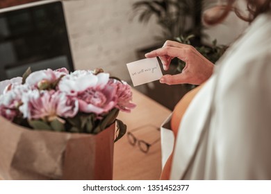 Bouquet of flowers. Happy sentimental woman receiving beautiful bouquet from her workmates while getting ready for maternity leave - Powered by Shutterstock