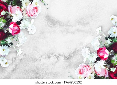 Bouquet of flowers on a concrete table. Red and pink roses, white daisies. Old white and gray background. Floral mockup for Birthday, Valentine`s day, Women`s day. Top view, flat lay, copy space