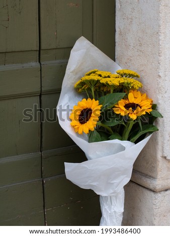 A bouquet of flowers from sunflowers left at the door. Floral business concept