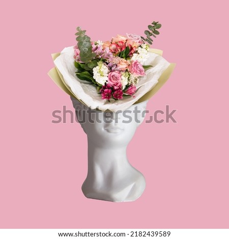 A bouquet of flowers in a vase in the form of female antique statue's head isolated on a pink background. 3d trendy collage in magazine style. Contemporary art. Modern design