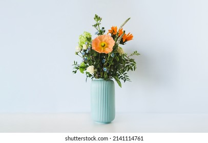 Bouquet Of Flowers In A Vase On A Light Background In The Interior. The Concept Is Flower Delivery.