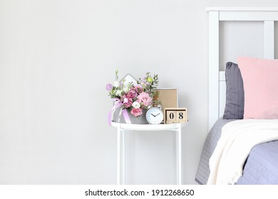 A Bouquet Of Flowers For A Woman On The Bedside Table On The Day Of The Holiday On March 8, St. Valentine's Day, Mother's Day, Wedding Day, Birthday. Flower Arrangement, Photo Frame, Alarm Clock.