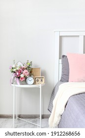 A Bouquet Of Flowers For A Woman On The Bedside Table On The Day Of The Holiday On March 8, St. Valentine's Day, Mother's Day, Wedding Day, Birthday. Flower Arrangement, Photo Frame, Alarm Clock.