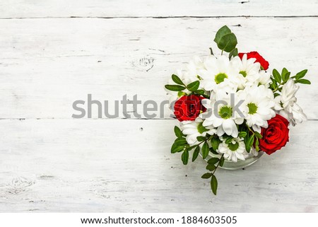 A bouquet of fresh flowers in glass vase. Valentine's day or Wedding concept. White old planks background