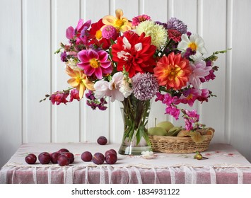 Bouquet Of Garden Flowers In A Glass Vase, Plums And Apples, Still Life In A Rustic Interior. Asters And Dahlias.