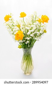 Bouquet Of The Globe Flowers And Lily Of The Valley In A Transparent Vase Isolated On White