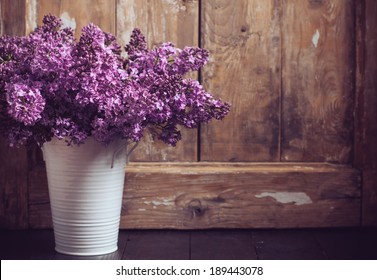 Bouquet of lilac flowers in a pot on a background of vintage wooden board, home decor in a rustic style - Powered by Shutterstock