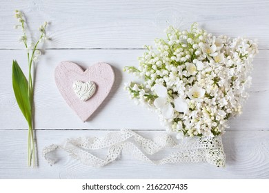 Bouquet of lilies of the valley, lilac flowers, apple flowers and a heart on a white wooden background. Postcard for wedding, Mother's Day, birthday. - Powered by Shutterstock