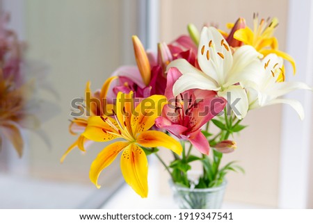 A bouquet of lilies in a vase in daylight