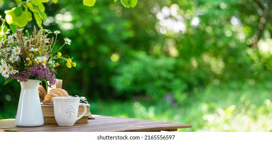 Bouquet Of Meadow Flowers, Croissant, Cup Of Tea Or Coffee, Books On Table In Summer Garden. Rest In Garden, Reading Books, Breakfast, Vacations In Nature Concept. Summertime In Garden On Backyard