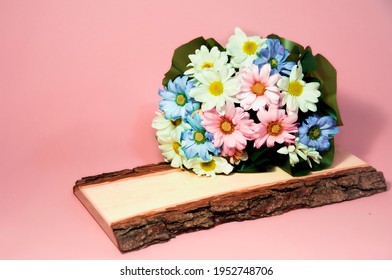 bouquet of multicolored chrysanthemums on a wooden plank and pink background. High quality photo - Powered by Shutterstock