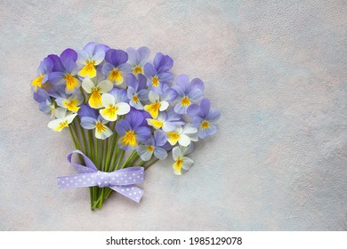 A bouquet of pansy viola flowers on a decorative colorful background, space for text, postcard.