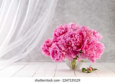 Bouquet of pink peonies in a vase on a wooden table. Gift Valentine's Day.