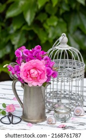 Bouquet Of Pink Rose And Vetches In Vintage Coffee Can In Garden