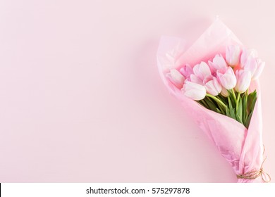 Bouquet of pink tulips wrappen in pink paper.