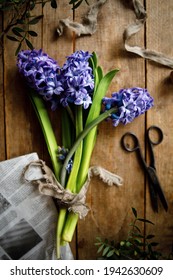 bouquet of purple hyacinth flowers on a wooden background with old vintage scissors. abstract composition with purple flowers. flowers top view