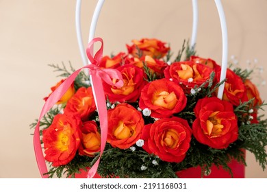 Bouquet Of Red Roses Decorated In Hat Box On Light Background. Tied Bow On Top. Flower Delivery Gift For Holiday. Flower Arrangement. Present Idea Greeting Card