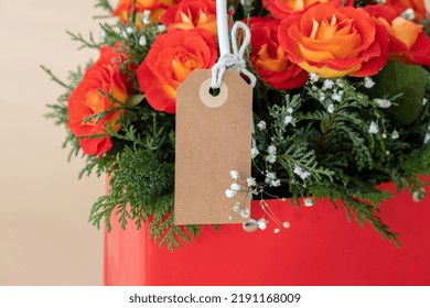 Bouquet Of Red Roses With Empty Paper Note Copy Space Decorated In Hat Box On Light Background. Tied Bow On Top. Flower Delivery Gift For Holiday. Flower Arrangement. Present Idea Greeting Card