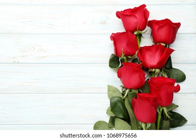 Bouquet Of Red Roses On White Wooden Table