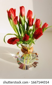 Bouquet Of Red Spring Tulips In A Glass Coffee Decanter On Taster's Flavor Wheel. White Background, Sunlight