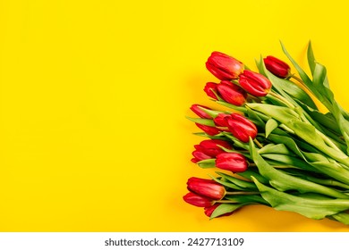 A bouquet of red tulips on a yellow background, a blank for advertising, postcards or other printed products. Top view. - Powered by Shutterstock