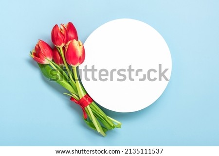 Bouquet of red tulips, white podium on blue background Top view Flat lay Holiday greeting card Happy moter's day, 8 March, Valentine's day, Easter concept Copy space Mock up