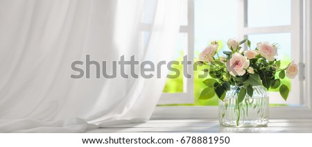 Bouquet of rose flowers near window with curtain