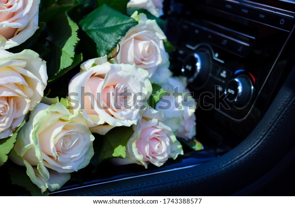 A bouquet of roses in car. Flower\
delivery. A bouquet for a date. the gift of\
flowers