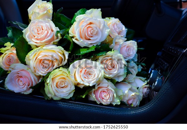 A bouquet of roses in car. Flower\
delivery. A bouquet for a date. the gift of\
flowers