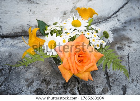 Bouquet of roses and daylilies. Yellow flowers in a bouquet of country style on a stone background.