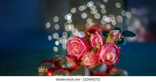 Bouquet Of Silk Pink, Red Roses And Blurred Dark Blue Background With Yellow Bokeh. Shallow Depth Of Field. The Artistic Intend And The Filters. Film Style Old Lens. Airy Atmosphere. Copy Space.