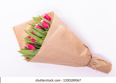 Bouquet Of Spring Tulips With Pink Flowers Wrapped In Paper For Present On White Background