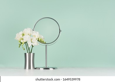 Bouquet sprint white fresh flowers and round mirror as elegant dressing table in trendy green mint menthe color, copy space.