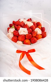 Bouquet of strawberries and roses on a white background. Bouquet of fruits and flowers. Copy space for a text. High quality photo