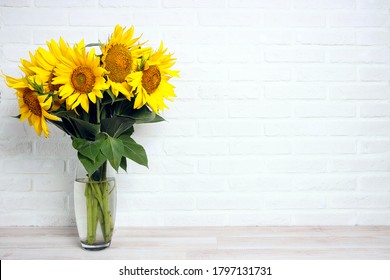 A bouquet of sunflowers in a vase against the background of a white brick wall. Сopy space for text. - Powered by Shutterstock
