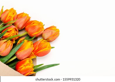 A bouquet of tulips in craft pack on a white background. Spring floral background. Copy space, Top view, flat lay.