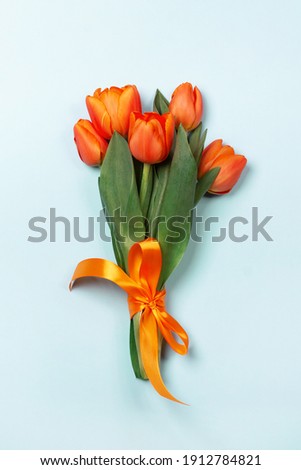 Bouquet of tulips in orange and rich red colors. Concept of Women's Day, Mother's Day, 8 March, the holiday greetings. Flat lay.