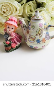 A Bouquet Of White Roses And A Porcelain Figurine